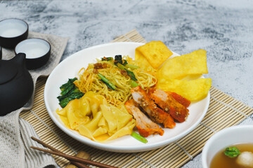 Egg noodle soup with red roasted pork and pork wontons Chinese food