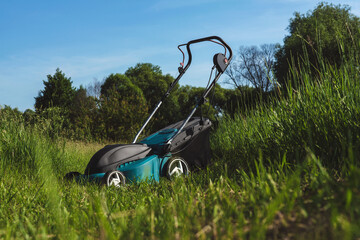 Electric Lawn Mower Resting in Lush Tall Grass Field