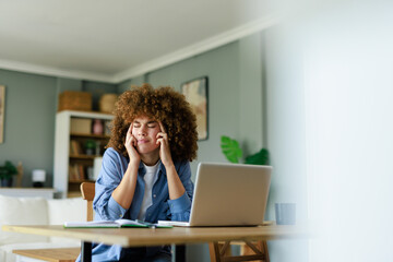 Young Woman Working from Home with Curly Hair Feeling Uncomfortable and Distracted