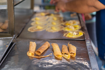 Tokyo pancakes with cream and quail eggs or fresh pile soft waffle roll dessert with custard sales by merchants people in local market and traditional street food for sweet snack in bangkok thailand