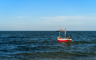 traditional red fishing boats or small old ancient wooden tourist boat and nobody floating in middle of sea in freedom ocean marine to skyline in Thailand on clear blue sky for summer holiday travel