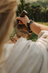 Close-up of female hands holding sound healing instruments. Tools for therapy, inner balance, and...