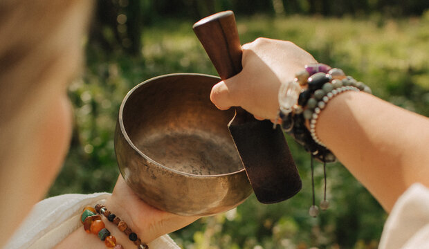 Close-up of female hands holding sound healing instruments. Tools for therapy, inner balance, and self-discovery through vibration, intention, and deep presence. Vintage ton. Soft focus, blurred