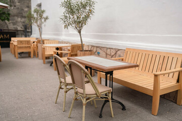 Restaurant furniture tables, chairs on patio provide outdoor dining at cafe on a bright day.