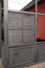 Shutters Dividers Facade: Grey dividers featuring shutters block view in outdoor area during...
