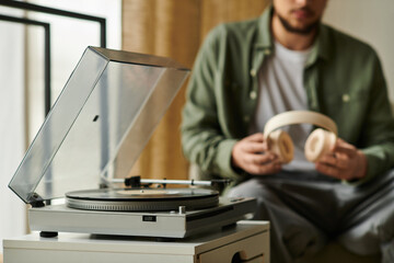 Young man enjoying music at home while relaxing in a cozy atmosphere with a vinyl record player