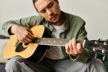 Young handsome man plays guitar at home, expressing creativity and passion through music
