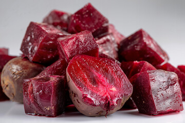 Close-up of vibrant red beetroot cubes with glossy texture on white surface
