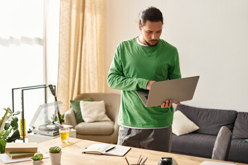 Young man working on laptop in cozy home setting while enjoying a refreshing drink
