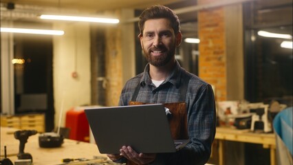 Positive Caucasian wood master man typing laptop online in workshop small business craftsman guy using computer device male joiner worker smile carpenter virtual shopping application Internet website