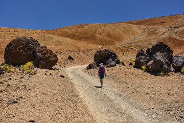 Woman hiking among lava boulders