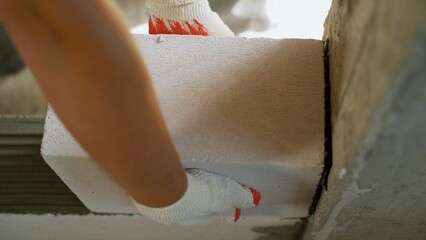 Construction worker carefully placing an autoclaved aerated concrete (aac) block, contributing to the efficiency and precision of modern building practices