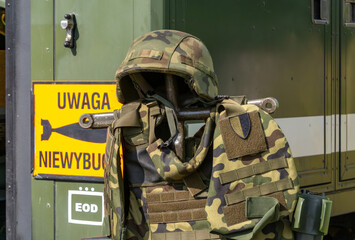 Camouflaged helmet and vest in front of a 