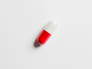 Red and white capsule pill on clean white background