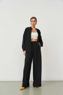 Stylish woman posing indoors in fashionable outfit with confidence and grace