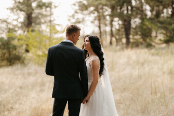 young couple a guy and a girl are walking in the green hills