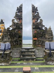 Balinese Temple Gate with Statues Overlooking a Lake