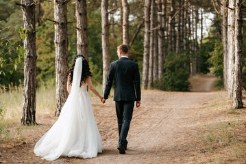 young couple a guy and a girl are walking in the green hills