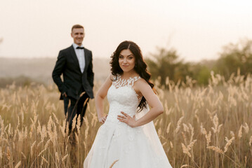 young couple a guy and a girl are walking in the green hills