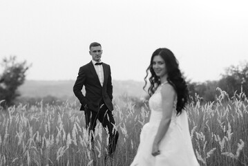 young couple a guy and a girl are walking in the green hills