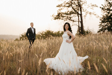 young couple a guy and a girl are walking in the green hills
