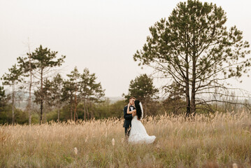 young couple a guy and a girl are walking in the green hills