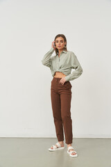 Stylish woman poses indoors in fashionable outfit, exuding confidence and elegance