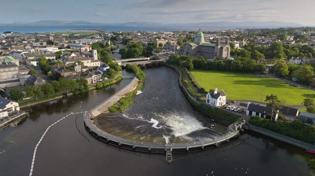 Aerial scenic views of Galway's River Corrib and city landscape on a sunny afternoon in summer. Fly over Galway, Ireland