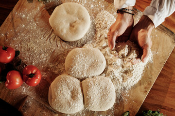Homemade fresh pasta making hand rolled dough flour dusted wooden cutting board cherry tomatoes...