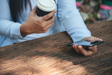 Close up women hands holding coffee cup smartphone E-commerce online Shopping website Reading...