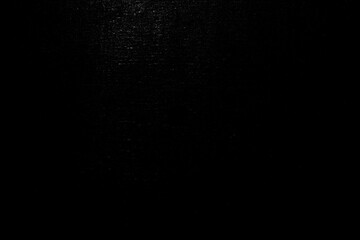 A close-up of a smooth black surface with light reflections, emphasizing texture and depth.