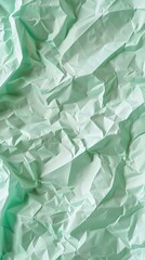 Crumpled pastel mint green paper background with gentle shadows and realistic grain detail for trendy aesthetic design