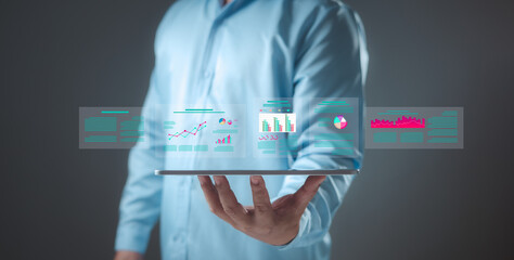 Person holds tablet displaying data dashboards with various charts and graphs. Business...
