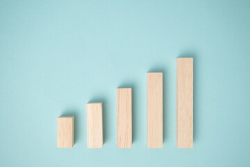 Minimal wooden blocks graph steps on blue background.