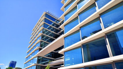 Downtown corporate business district architecture. Glass reflective office buildings against blue...