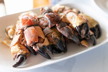 Steamed stone crab claws served with a spicy seafood dipping sauce are popular dishes in local street food in Thailand.