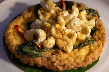 Thai style crispy fried eggs with pork crackling and herbs.