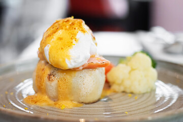 A delicious serving of poached eggs with salmon and a dollop of hollandaise sauce on a bed of creamy cauliflower.