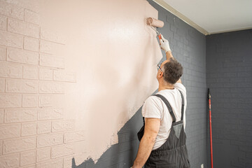 Man Painting Brick Wall With Paint Roller