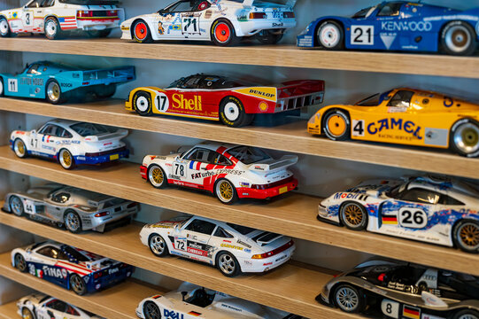 Collection of sport model cars displayed on wooden shelves