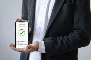 A person in a suit holds a smartphone displaying a Payment Successful screen with a green checkmark.