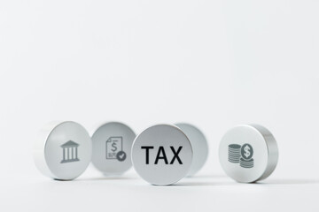 Round tokens with the word TAX and other financial icons like a bank and coins are arranged on a white background.
