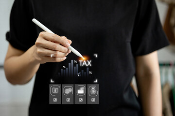 A person uses a stylus to interact with a digital interface for calculating taxes, showing...