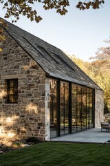 Obraz premium Modern stone house integrates glass in scenic landscape, showcasing contemporary architecture against a backdrop of trees and blue skies during daylight