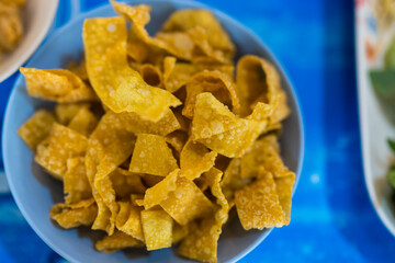Fried crispy wonton strips in a bowl, free service at noodle restaurants, appetizers