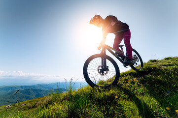 Cyclist man riding mountain bike outdoors. Male tourist riding bicycle on grassy path in mountains...