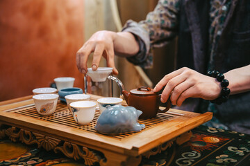 Preparing Tea With Clay Teapot And Tiny Cups