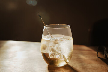 Chilled Glass of Sake With Ice on Wooden Table