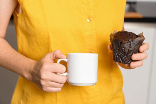 Woman Holding Chocolate Muffin And Coffee Mug