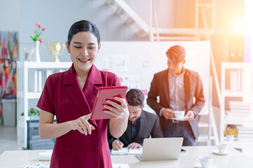 Portrait of young Asian businesswoman using digital tablet in office.